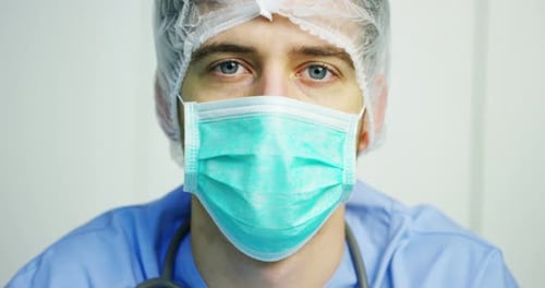 close up portrait of a surgeon or doctor with mask and headset ready for operation in hospital or