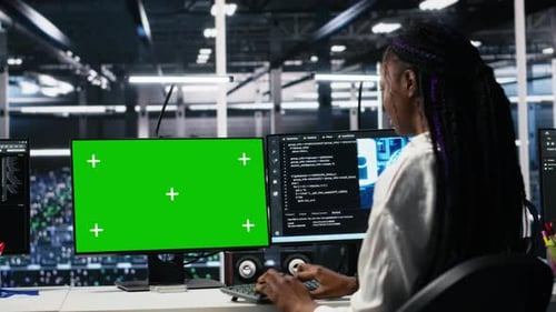 Softwareentwickler für Rechenzentren, der KI-Systeme mithilfe eines Greenscreen-PCs verwaltet