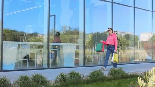 Confident Female Going Through City with Multicoloured Bags