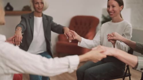 Thérapie de groupe avec des femmes psychologues professionnelles se tenant la main en gros plan, affirmation et méditation
