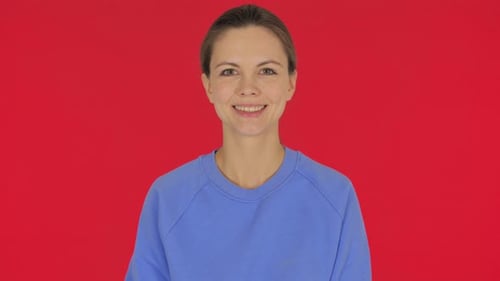 Woman Smiling in a Blue Shirt on Red