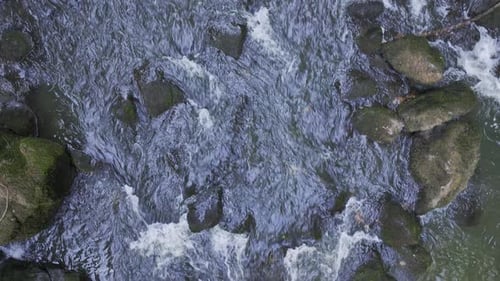 Looking Down On The River With Water Rushing Through The Stones Flying Above Aerial Shot