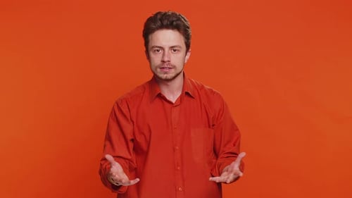 Man Talking and Gesturing on Orange Background