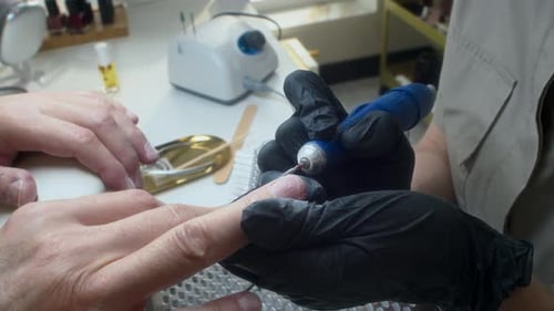Manicurist Using Electric File on Customer's Nails