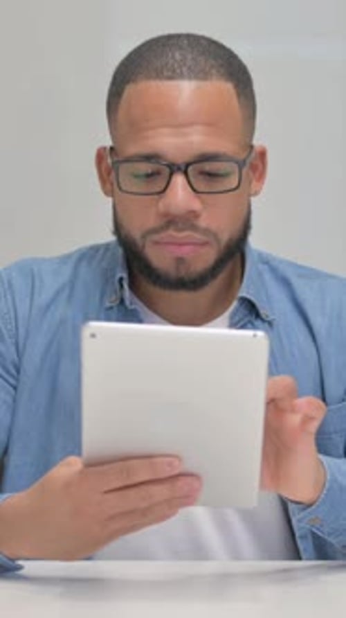 Man Using Tablet Device Indoors Against White Background