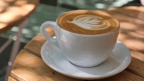 Enjoying a Beautifully Crafted Latte in a Cozy Cafe