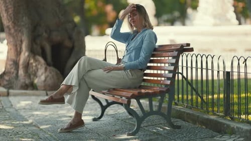 Femme assise sur un banc dans un parc pendant une