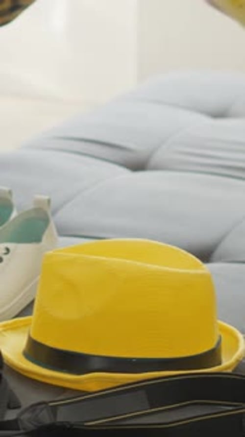 Person Packing Yellow Suitcase with Travel Accessories