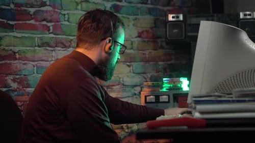 Dans les années 1980, un homme devant un ordinateur de bureau commence à jouer de la musique sur une cassette Audio vintage