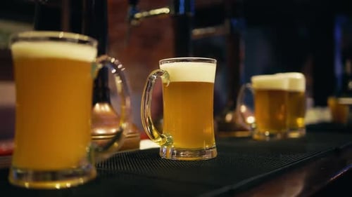 Pouring Beer Into a Glass with Bubbles By the Bartender