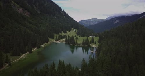 Aerial shot of an lake of mountains surrounded by nature in a magical, relaxing and green place.