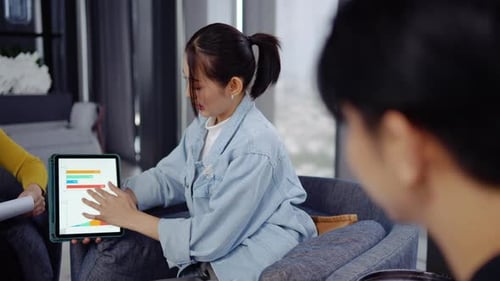 Woman Presents Data on Tablet at Modern Office