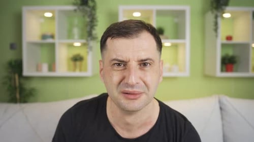 Sweaty man with fear and anxiety looking at camera, getting depressed, constricting.