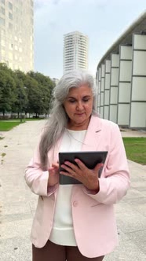 Woman Holding Tablet Device Outdoors in City Setting