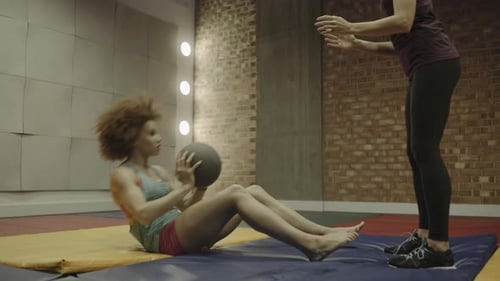 Young woman and personal trainer exercising abdomen