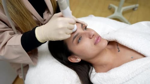 Woman Receiving Facial Cosmetic Treatment at Modern Clinic