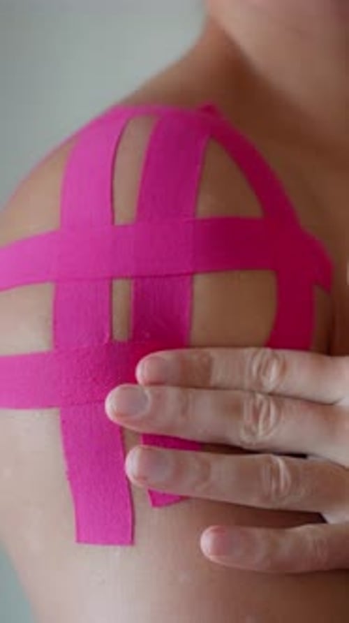 Pink Medical Tape Applied on Person's Shoulder
