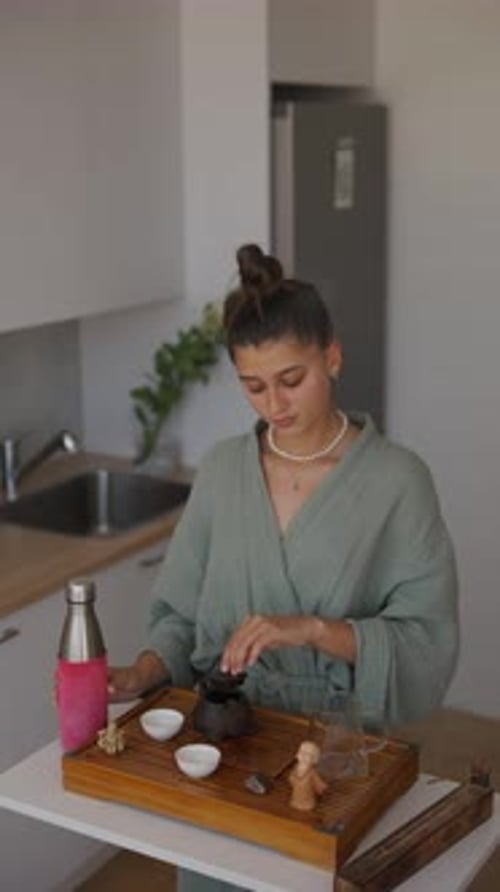 Woman Indoors Pours Hot Water Into Tea Pot