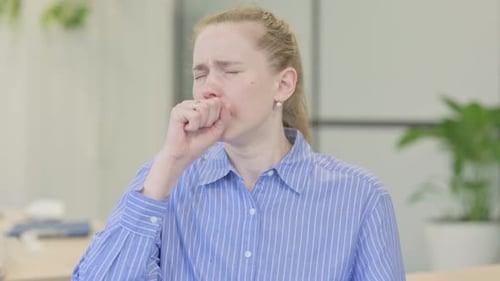 Portrait of Sick Young Woman Coughing in Office