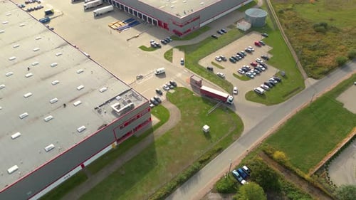 Aerial view of a semi trucks with cargo trailers standing on warehouses ramps for loading/unloading