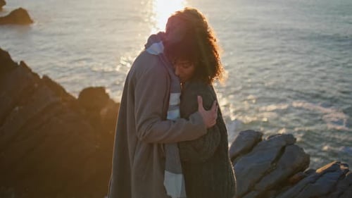 Romantic Couple Embracing by Ocean at Sunset