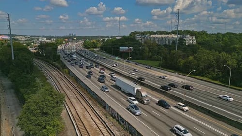 Drone shot showing busy multi-lane highway in Atlanta City during sunny sky