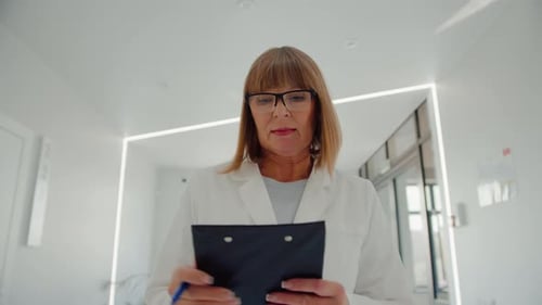 Female Doctor Walks Down Hospital Hallway