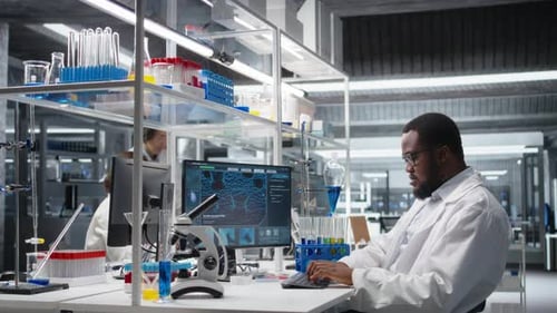 Man Typing at Computer in Bright Modern Laboratory
