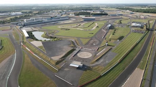 Vista aérea volando a través de las curvas y rectas del circuito de Silverstone, circuito asfaltado de deportes de motor de F1