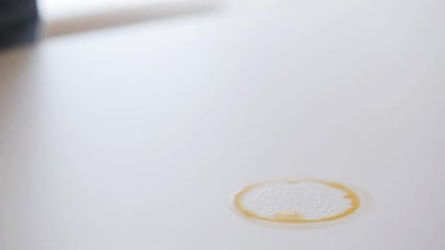 Cleaning up spilled coffee with a blue cloth