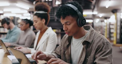 Man, student and typing on laptop in library for writing assignment essay