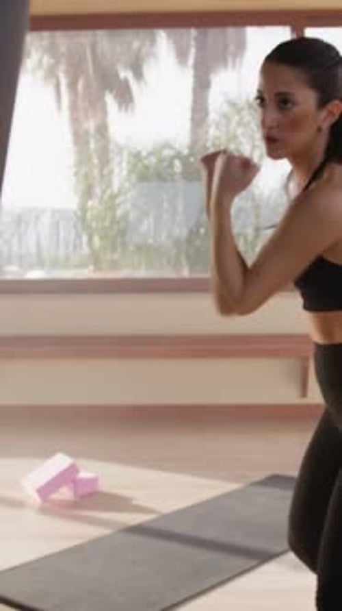 Woman Working Out on Punching Bag at Home