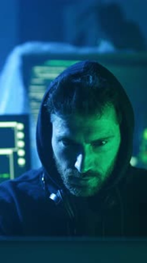 Ein Mann, der einen Hoodie trägt, konzentriert sich intensiv auf einen Computerbildschirm