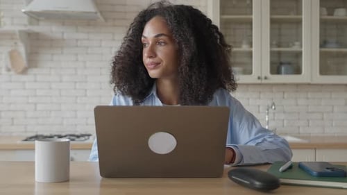Woman Works on Laptop at Kitchen Table