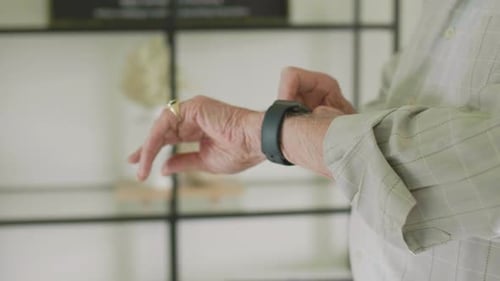 Senior Man Using Smart Watch at Home 8089 Years