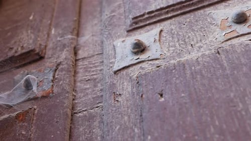 Panning left on an old wooden gate to reveal a webcob