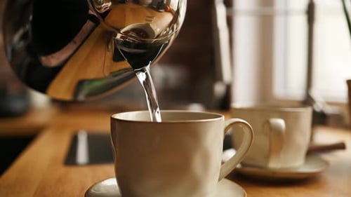 Tea Preparation with Teapot and Cups at Kitchen