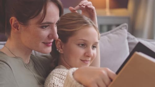 Mother and Daughter Reading a Book Together at Home