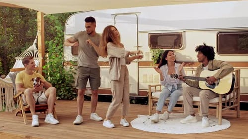 Young Friends Sing and Dance Outside Vintage Trailer