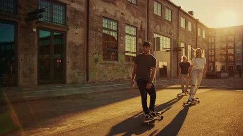 Group of Girls and Boys on Skateboards Through Fashionable Hipster District. Beautiful Young People