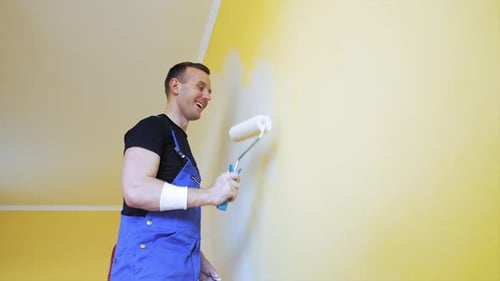 Painter with a paint roller in action.