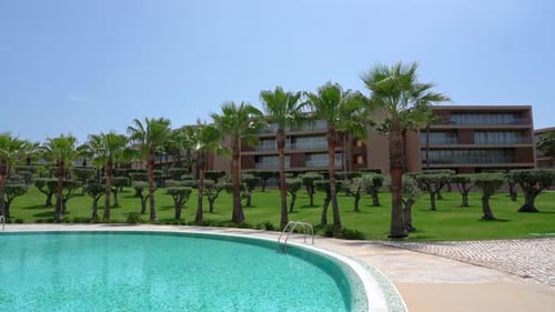 Hotel mit Swimmingpool mit klarem blauem Wasser mit Palmen