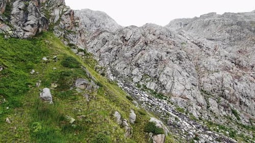 Green Mountain Slope Merging with Rocky Cliff in Summer