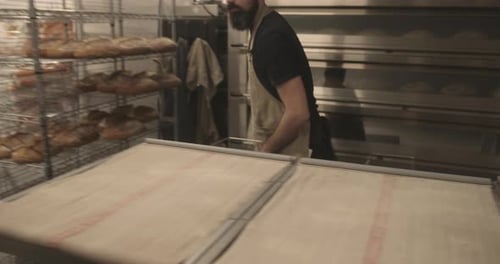 Busy Male baker preparing sourdough bread before baking in oven in bakery