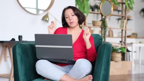 Woman Celebrates Good News While Using Laptop