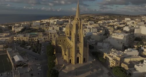 Aerial view of church overlooking coast at sunset, Malta.