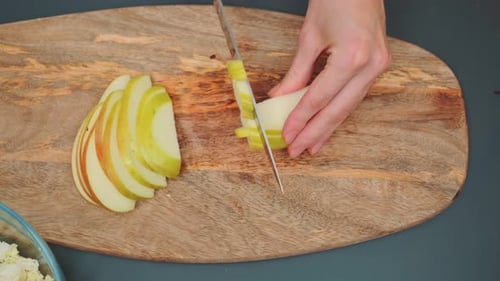 Person Dicing Apple on Wooden Cutting Board
