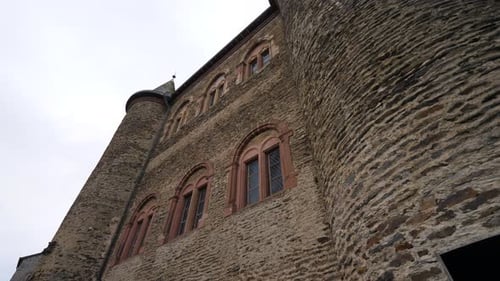 Outside wall of medieval European castle with windows in winter