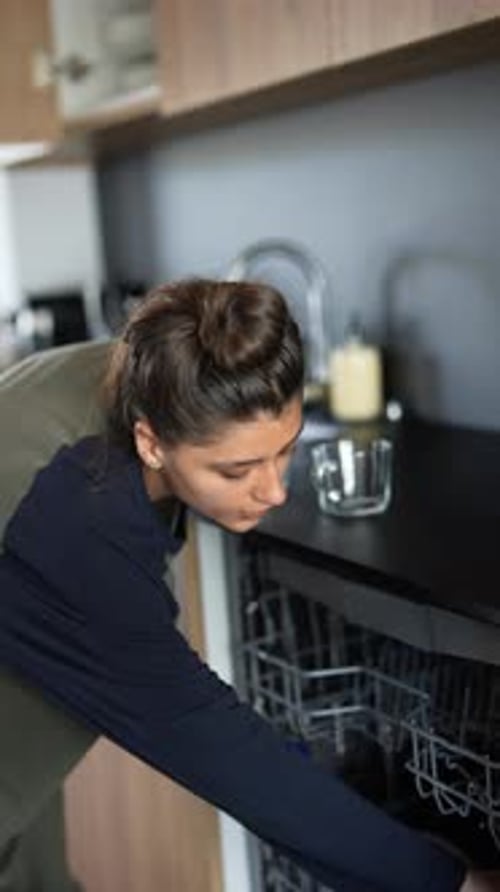 A Woman is Busy Tidying Up the Kitchen Cabinet in a Modern and Classy Household