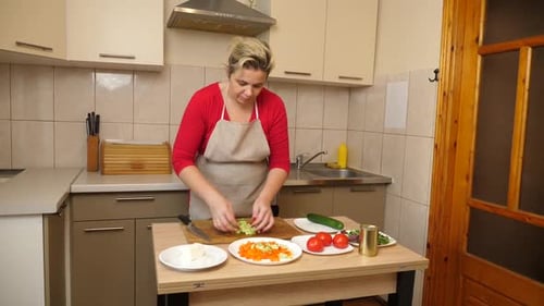 41 1. Eine Frau bereitet einen Salat aus Gemüse, Käse und Oliven zu. Hausmannskost.